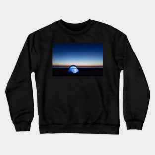 Illuminated tent on the beach by the sea at dawn Crewneck Sweatshirt